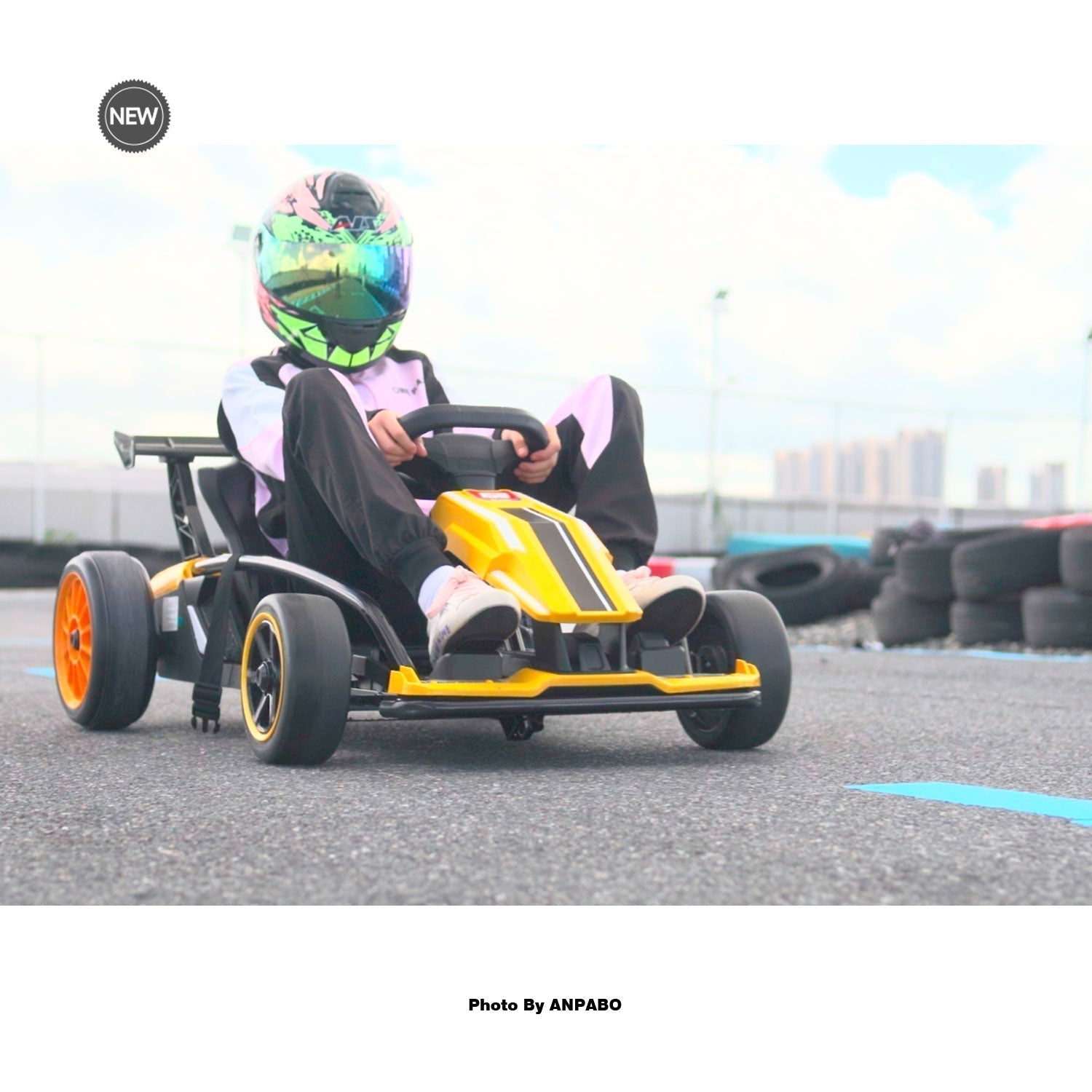 Child driving an ANPABO 24V yellow and black electric go-kart on an outdoor track