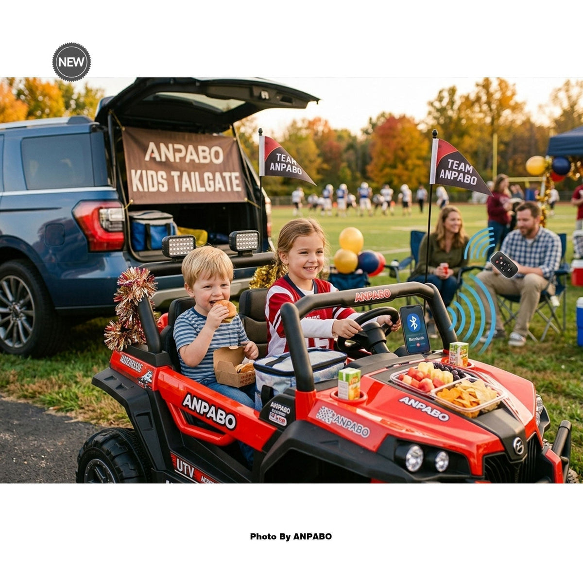 A boy and a girl enjoying a kids tailgate experience in a red 24V Anpabo ride-on car equipped with a snack station, parked next to an SUV on game day.
